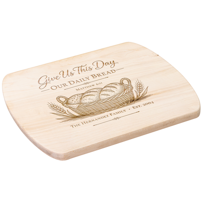 Angled view of a personalized maple oval board engraved with Give Us This Day Our Daily Bread, Matthew 6:11, bread and wheat.