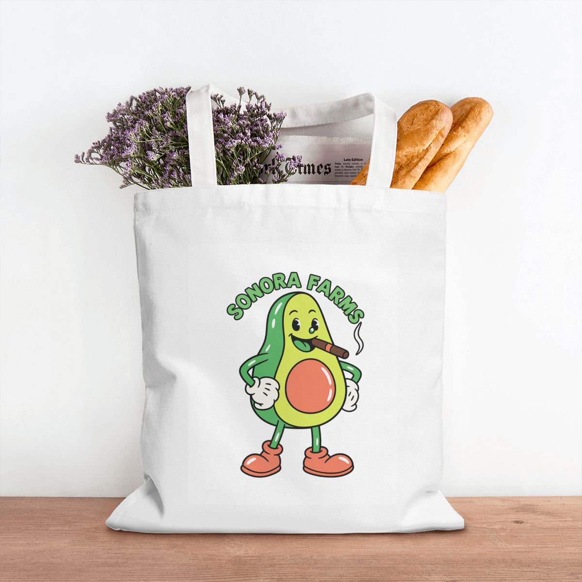 White canvas tote with a sample Sonora Farms logo holding groceries; contents are not included.